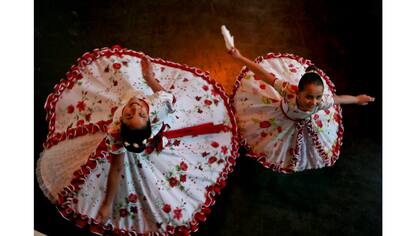Josefa, de 13 años, y Selenna, de 8 años, posan para una foto vistiendo sus trajes tradicionales de baile chileno antes del evento que marca el Día del Niño Transgénero en Santiago de Chile