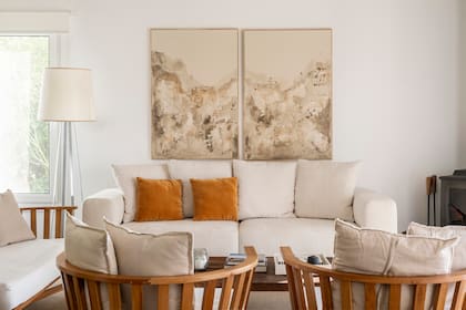 Las obras, de Hermanas Muñoz, fue un regalo que la arquitecta le hizo a la familia para esta casa. Sillón hecho a medida (MTD Arquitectura) combinado con sillones estilo Gervasoni. Lámpara de pie (Solsken).