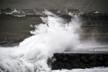 Las olas rompen al final de la pista del aeropuerto de Sumburgh, en las Islas Shetland, cuando el clima severo de la tormenta Ingunn afecta los vuelos y los viajes en ferry, 31 de enero de 2024. (Andy Buchanan / AFP)