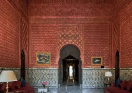 Las paredes de color rojo intenso y los azulejos arabescos adornan esta estancia