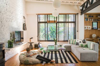 Las persianas de madera regulan la luz sin robar espacio; y parecen hechas a imagen y semejanza del piso de pino tea original, pulido e hidrolaqueado.