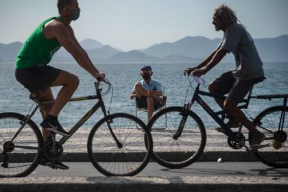 Las personas circulan en bicicleta y llevan mascarillas en Río de Janeiro, Brasil