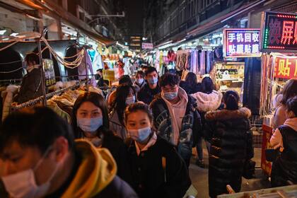 Las personas con tapabocas caminan por un mercado en Wuhan, provincia central de Hubei en China, el 5 de febrero de 2021