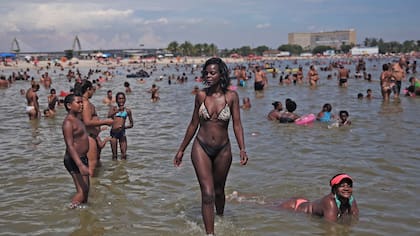 Las personas disfrutan del día en el estanque artificial conocido como piscinao, en los suburbios del norte de Río de Janeiro, Brasil