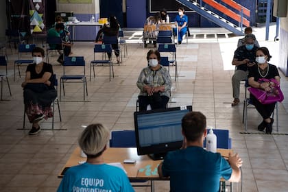Las personas esperan su turno para ser inoculadas contra el Covid-19 en un centro de vacunación en Santiago de Chile, el 1 de marzo de 2021