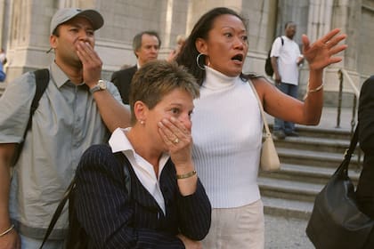 Las personas frente a la Catedral de San Patricio de Nueva York reaccionan con horror mientras miran por la Quinta Avenida hacia las torres del World Trade Center después de que los aviones se estrellaran contra sus pisos superiores