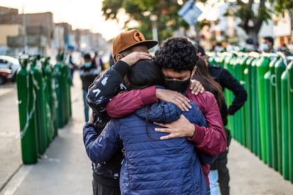 Las personas hacen fila para llenar sus cilindros de oxígeno vacíos en Callao, Perú, el 29 de enero de 2021 en medio de la pandemia del coronavirus