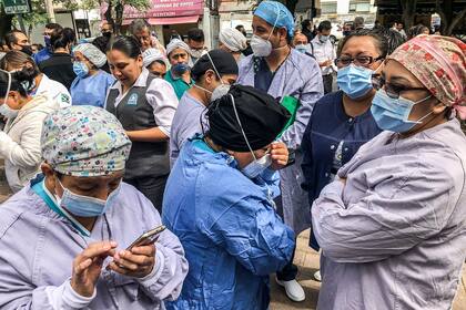 Las personas permanecen fuera de la clínica de Durango en la Ciudad de México durante un terremoto el 23 de junio de 2020 en medio de la pandemia de coronavirus