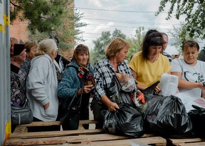 Las personas que fueron evacuadas de las regiones fronterizas, incluida Sudzha, hacen fila para esperar la distribución de ayuda de House of Good Deeds, una organización local, en Kursk, Rusia, el martes 13 de agosto de 2024.