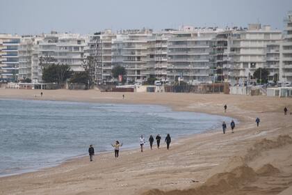 Las personas salen a caminar por una playa en Francia a medida que se relaja el confinamiento por el coronavirus
