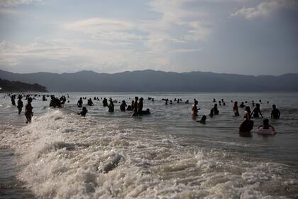 Las personas se refrescan en el mar ante el calor en el balneario Jurere en Florianópolis.