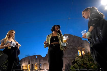 Las personas se reúnen para tomar un aperitivo frente a un bar junto al Coliseo en Roma, el 18 de mayo de 2020