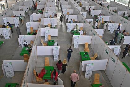 Las personas se reúnen para vacunarse contra el coronavirus con la fórmula de Sinopharm en el centro de exposiciones de Lahore, Paquistán, el 28 de abril de 2021