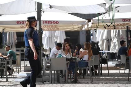 Las personas se sientan en un bar en la Plaza Mayor de Madrid el 25 de mayo de 2020, luego de que las medidas de bloqueo del coronavirus finalmente se flexibilizaron para las personas en Madrid y Barcelona
