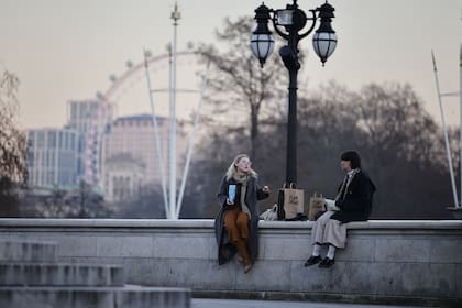 Las personas se sientan manteniendo la distancia social en el centro de Londres el 9 de enero de 2021 mientras la vida continúa bajo el tercer bloqueo de Gran Bretaña en un intento por controlar los crecientes casos de Covid-19