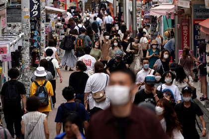 Las personas usan máscaras faciales para ayudar a frenar la propagación del coronavirus caminan por una calle comercial en Tokio, el viernes 3 de julio de 2020. Japón levantó una emergencia estatal pandémica de siete semanas a fines de mayo, y desde entonces las actividades sociales y comerciales se