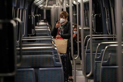 Las personas viajan en un tren de metro, el 17 de octubre de 2020 en París, al comienzo de un toque de queda nocturno implementado para combatir la propagación de la pandemia
