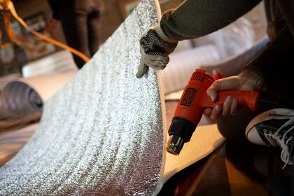 Las pistolas de calor de 1500 watts sellan el material aislante y así, la bolsa se convierte en un refugio para mantener la temperatura del cuerpo