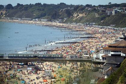Las personas intentan ejercer cierto distanciamiento mientras disfrutan del clima caluroso en Bournemouth