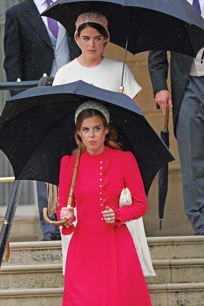 Las princesas de York, Beatriz (adelante) llevó un vestido Beulah London y decoró su pelo con una vincha de Emily London; y Eugenia apostó a un vestido midi en crêpe de Chine de Ulla Johnson, que accesorizó con un tocado de Alice Archer para Emily London.