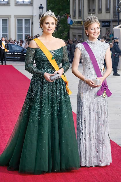 Las princesas herederas de Países Bajos y Bélgica ocuparon un lugar especial en cada uno de los actos y, a su llegada a la comida de gala, fueron ovacionadas. Para esa ocasión, Amalia eligió un vestido de Monique Lhuillier en color verde, con cristales y lentejuelas, pronunciado escote en V, falda de tul en línea trapecio y ceñido a la cintura, perfecto para lucirlo con la tiara de la reina Emma. Elisabeth, por su parte, apostó por un diseño plateado de Jenny Packham cubierto de lentejuelas, que potenció con la tiara de diamantes que sus padres le regalaron para su cumpleaños número 18