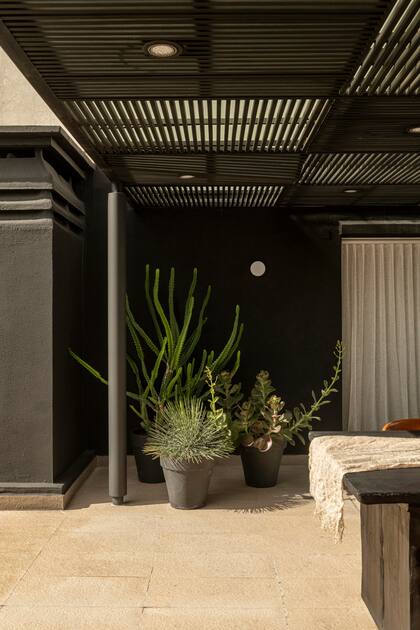 Las puertas corredizas con sus cortinas de lino que comunican el living con la pérgola transmiten una sensación de casa a este departamento en un décimo piso.