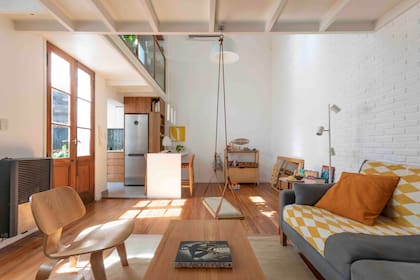 Las puertas de doble hoja que conectan el estar con el patio –y que conforman el ingreso principal de la casa– son originales y fueron restauradas. También recuperaron el piso de pino tea, que pulieron e hidrolaquearon.