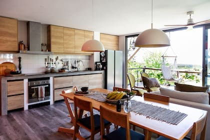 Las puertas ventana integran el afuera con el adentro. En la cocina: camino, frutera, vajilla, todo de Gloria Atelier (@gloriaatelierdeco); aromatizador y velas de AA Elements (@aaelements)