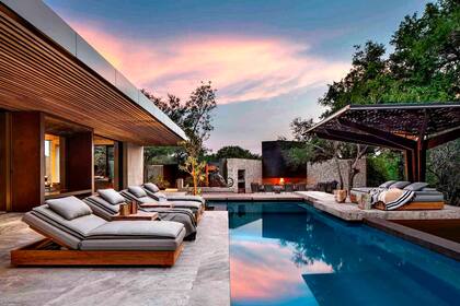 Las reposeras junto a la pileta ofrecen un espacio de relajación con vista directa a la sabana.