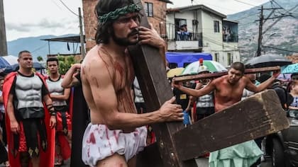 Las representaciones del calvario de Cristo cargando la cruz se repiten en varios puntos del planeta. Esta recreación es del jueves santo en Medellín, Colombia