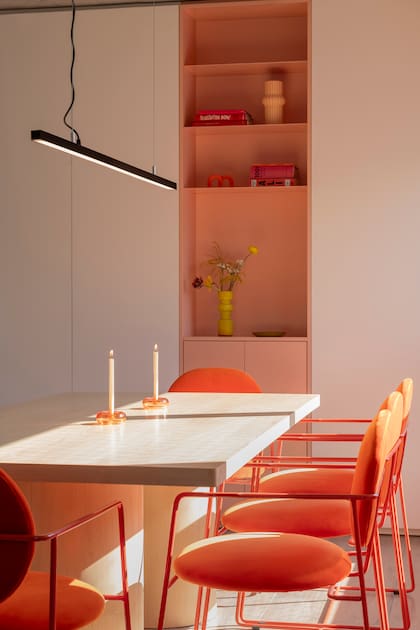 Las sillas del comedor (Bull Buenos Aires) se tapizaron en un terciopelo a tono con el nicho. Una lámpara minimalista al extremo (Huup Iluminación) y un juego de candelabros de vidrio son el único ornamento.