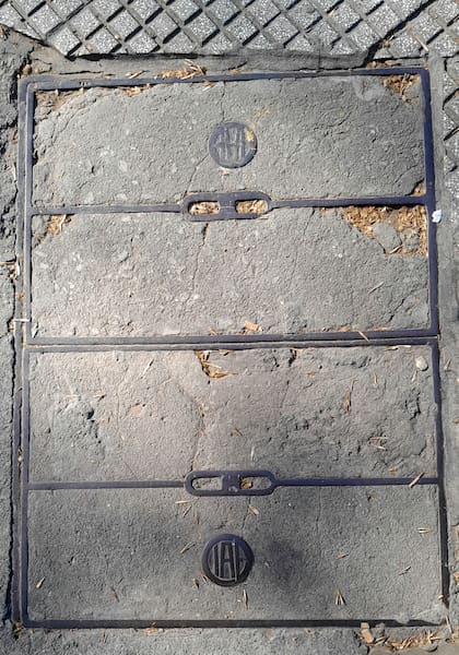 Las tapas "de piso" de CIAE combinan metal y cemento. La foto fue tomada en una esquina de Balvanera