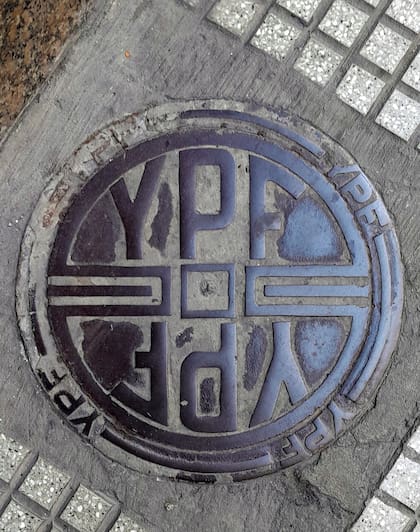 Las tapas de YPF esconden viejos tanques de combustibles, en esquinas o garages de la ciudad, donde alguna vez hubo surtidores