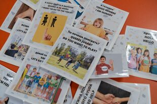Las tarjetas con mensajes en español traducidas al inglés y ruso son acompañadas por fotos y dibujos para los alumnos que recién están aprendiendo a leer y escribir