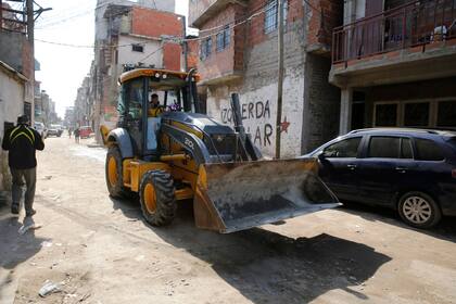Las topadoras llegas para llevarse los escombros de las casa que serán demolidas