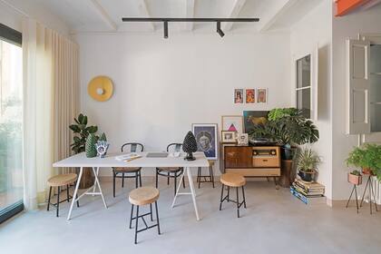 Sobre la mesa con caballetes, clásica cerámica blanca y azul de Sargadelos y tradicional piña siciliana de Managò. El aplique de pared ‘Globe Fold’ es un diseño del Estudio CaSA producido por Metalware.