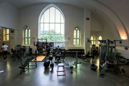 Las ventanas neogóticas de la iglesia parecen incongruentes con la sala de pesas de Saint Jude