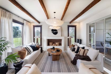 Las vigas en madera de castaño (Familia Echaide) no son meramente decorativas, tienen una función real. Aberturas de PVC símil madera color 'Toffee' (Muchtek). Sillones, alomohadones, alfombra y mesa de centro (Sol Palou Deco).