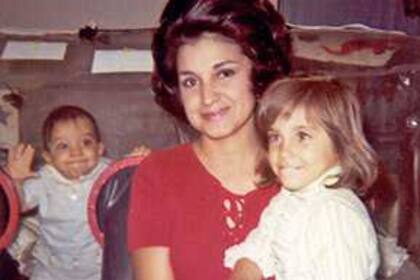 Laura Ann y Katherine, hermana y madre del niño de la burbuja, sonríen para la foto mientras el pequeño David Vetter sonríe detrás de ellas