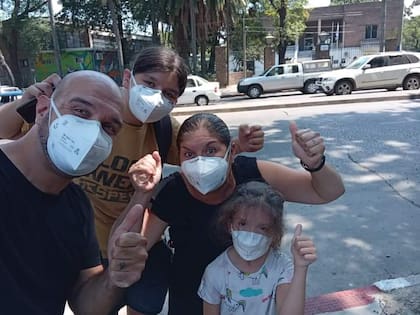 Laura Santi y su familia con la escuela de Montevideo donde su hija, Maia, recibió la primera dosis de la vacuna