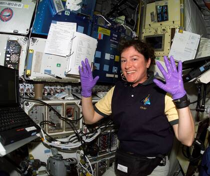 Laurel B. Clark, con guantes púrpura, trabaja en un experimento, en el espacio.