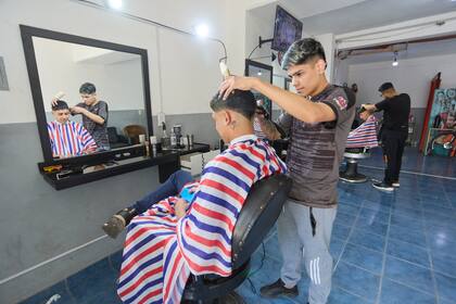 Lautaro y Miguel en una peluquería de El Algarrobal. Ambos votan a Milei.