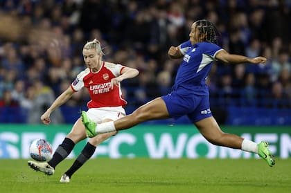 Leah Williamson, de Arsenal y con las medias con cinta adhesiva, lanza el centro ante la presión de Lauren James, de Chelsea, en el Stamford Bridge. 