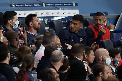 Leandro Paredes intenta entender el cambio de Pochettino y charla con Messi; sus compañeros observan con incredulidad y hasta el público dejó de ver el partido para fotografiar el disgusto de Messi