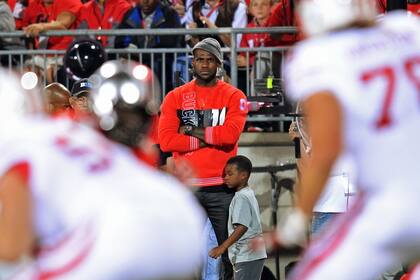 LeBron James nunca perdió su cariño por el fútbol americano, deporte que práctico con cierto éxito durante su secundaria. Aquí, viendo un partido con su hijo.