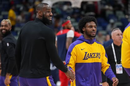 LeBron saluda a su hijo, el escolta Bronny James, durante los calentamientos antes de un partido contra los Pelicans de Nueva Orleans en Nueva Orleans, el sábado 16 de noviembre