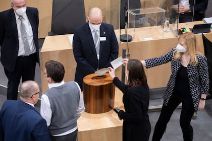 Legisladores austriacos someten a votación un mandato de vacuna obligatoria contra el COVID-19 en el Parlamento en Viena, Austria, el jueves 20 de enero de 2022. (AP Foto/Lisa Leutner)