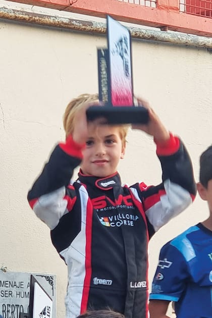 León alza su trofeo después de ganar una complicada carrera de karting en la que largó en el décimo puesto por una penalización técnica.