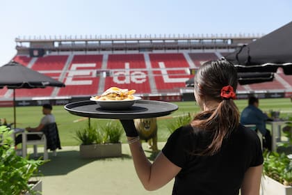 León no solo está ubicado dentro del estadio de Estudiantes de La Plata, sino que directamente está en la cancha, con mesas que tocan el césped