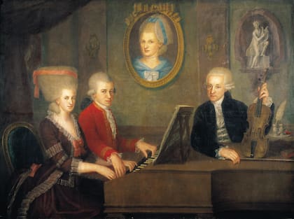 Leopold, a la derecha, con sus hijos, Wolfgang y Nannerl. En la pared, cuelga el retrato de la madre, Anna Maria, quien había muerto. Obra del artista Johann Nepomuk Della Croce.